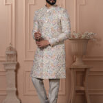 Man wearing pastel Indo-Western with intricate multicolor printed motifs.