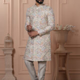 Man wearing pastel Indo-Western with intricate multicolor printed motifs.