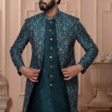 Man wearing teal Indo-Western with embroidered jacket and gold buttons.