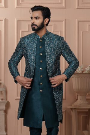 Man wearing teal Indo-Western with embroidered jacket and gold buttons.