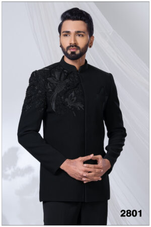 Man wearing a black embroidered Jodhpuri suit with detailed bird motifs on the shoulder and chest.