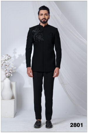 Man wearing a black embroidered Jodhpuri suit with detailed bird motifs on the shoulder and chest.