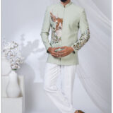 Sage green Jodhpuri with embroidered deer and floral motifs, paired with white bottoms.