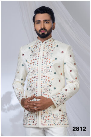 Man wearing an ivory embroidered Jodhpuri suit with multicolored floral motifs and mandarin collar.