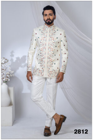 Man wearing an ivory embroidered Jodhpuri suit with multicolored floral motifs and mandarin collar.