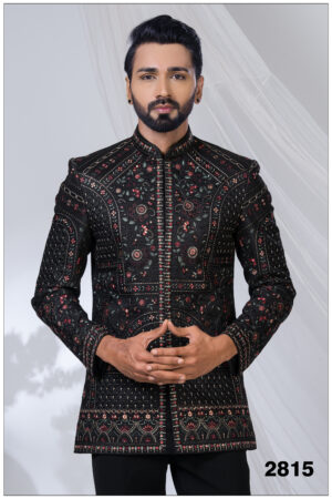 Man wearing a black embroidered Jodhpuri suit with intricate red and gold threadwork and mandarin collar.