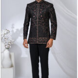 Man wearing a black embroidered Jodhpuri suit with intricate red and gold threadwork and mandarin collar.