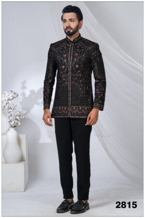 Man wearing a black embroidered Jodhpuri suit with intricate red and gold threadwork and mandarin collar.