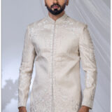 Man wearing an ivory Jodhpuri suit with pearl embroidery, floral motifs, and a mandarin collar.