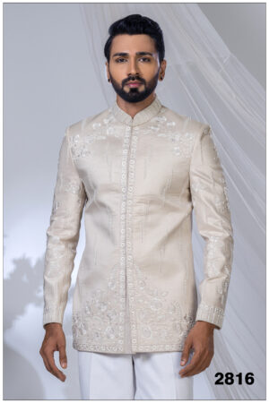 Man wearing an ivory Jodhpuri suit with pearl embroidery, floral motifs, and a mandarin collar.