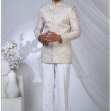 Man wearing an ivory Jodhpuri suit with pearl embroidery, floral motifs, and a mandarin collar.