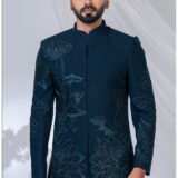 Man wearing a teal Jodhpuri suit with lotus embroidery, sequin detailing, and mandarin collar.