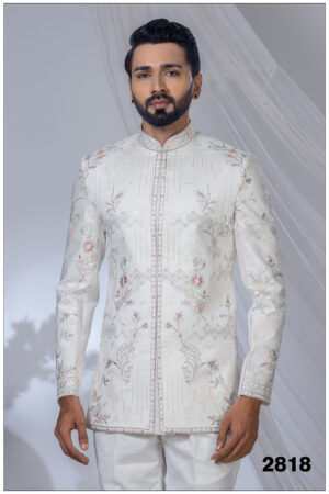 Man wearing an ivory Jodhpuri suit with pastel floral and geometric embroidery and a mandarin collar.