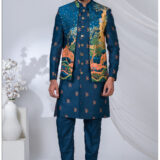 Man wearing a royal blue Open Indowestern suit with artistic landscape embroidery in gold, green, and coral tones, paired with metallic buttons.