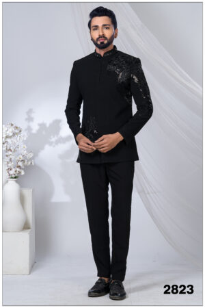 Man wearing a black Jodhpuri suit with intricate eagle motif embroidery on the chest and sleeve.