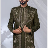 Man wearing an olive green Indo-Western outfit with heavy embroidery featuring peacocks, deer, floral vines, and traditional motifs.