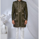Man wearing an olive green Indo-Western outfit with heavy embroidery featuring peacocks, deer, floral vines, and traditional motifs.