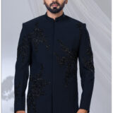 Man wearing a black Jodhpuri suit with abstract bead embroidery and mandarin collar.