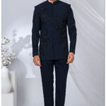 Man wearing a black Jodhpuri suit with abstract bead embroidery and mandarin collar.