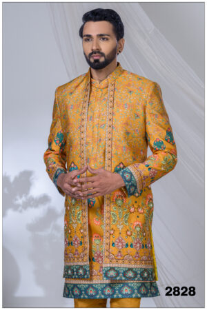 Man wearing a mustard Indo-Western outfit with floral multicolor prints and teal-red border accents.