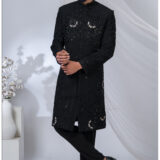 Man wearing a black Indo-Western sherwani with detailed black embroidery and beadwork.