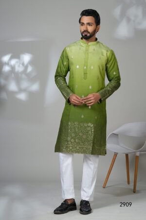 Man wearing a multicolor floral printed kurta with mirror work embroidery on the neckline, paired with white trousers and black loafers, standing indoors against a neutral backdrop.