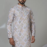 Man wearing a lilac embroidered kurta with mirror and thread work, white trousers, and brown shoes—a statement ethnic wear look.