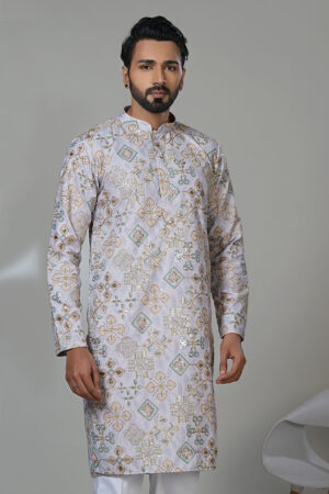 Man wearing a lilac embroidered kurta with mirror and thread work, white trousers, and brown shoes—a statement ethnic wear look.