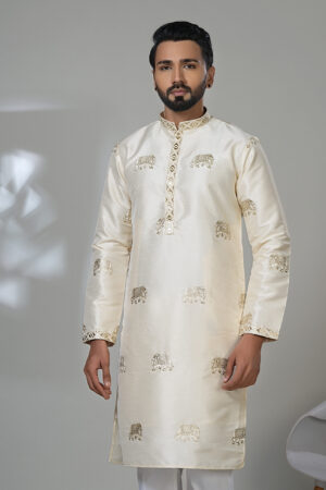 Man wearing an ivory silk kurta with gold elephant embroidery, white trousers, and brown shoes — perfect for festive or formal Indian wear.