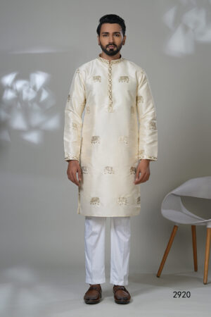 Man wearing an ivory silk kurta with gold elephant embroidery, white trousers, and brown shoes — perfect for festive or formal Indian wear.