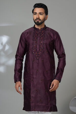 Man wearing a deep maroon embroidered kurta with white pants and black shoes, perfect for formal festive wear.