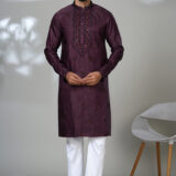 Man wearing a deep maroon embroidered kurta with white pants and black shoes, perfect for formal festive wear.