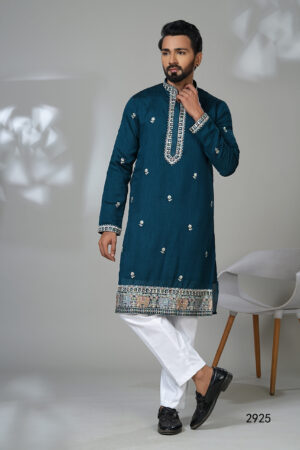 Man wearing a teal kurta with mirror embroidery and elephant motif border, paired with white pants.
