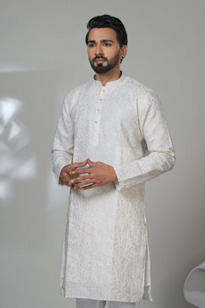 Man in an ivory kurta with mirror work and white pants, styled in a modern ethnic look.
