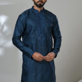 Men’s navy blue kurta with intricate embroidery and white trousers