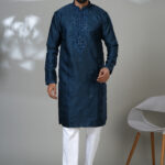 Men’s navy blue kurta with intricate embroidery and white trousers