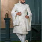 Ivory silk groom sherwani with architectural embroidery and pastel detailing