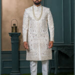 Ivory silk sherwani with floral zari and sequin embroidery for groom.