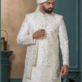 Ivory sherwani with zardosi and resham embroidery, detailed floral and geometric motifs, and maroon thread highlights on a rich jacquard fabric.