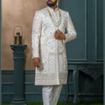 Ivory silk sherwani with golden zari embroidery and pearl accessories for groom