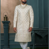 Ivory sherwani with gold embroidery and peacock design for groom wedding wear.