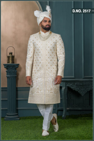 Ivory sherwani with gold embroidery and peacock design for groom wedding wear.