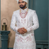 Ivory sherwani with heritage embroidery featuring royal motifs of elephants and musicians for wedding wear