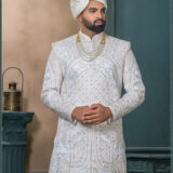 Ivory sherwani with intricate golden geometric and arch embroidery, ideal for grooms seeking a royal traditional look.