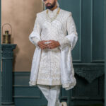Ivory sherwani with intricate golden geometric and arch embroidery, ideal for grooms seeking a royal traditional look.