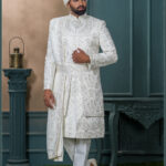 White embroidered sherwani with resham and mirror detailing, designed for a royal groom look.