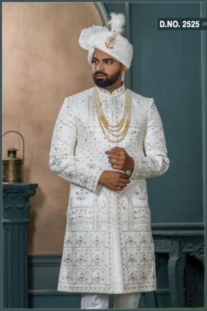 White zardozi embroidered sherwani for groom with intricate threadwork and royal turban.