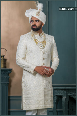 Ivory sherwani for groom with sequin and thread embroidery, paired with royal turban and pearl mala.