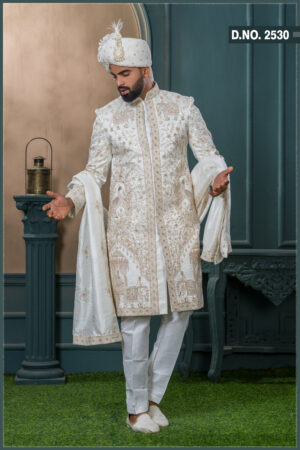 Ivory sherwani with elephant and peacock zardozi embroidery, styled with a cream turban and feather, ideal for a royal groom look.