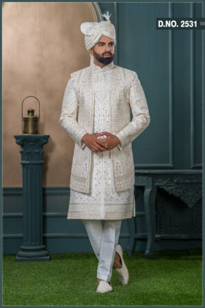 Ivory sherwani with intricate gold zardozi embroidery and turban with feather, styled for an elegant groom look.